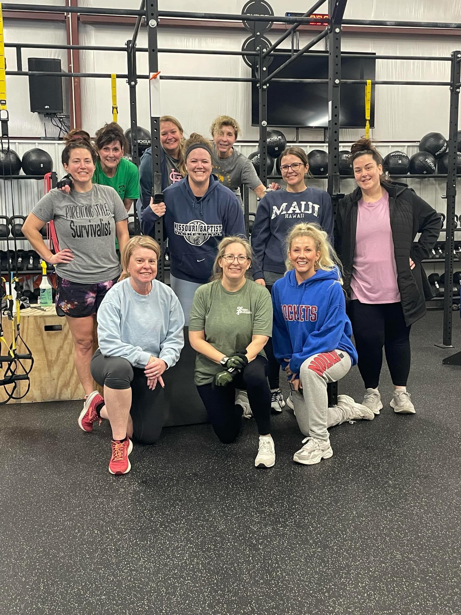 A group of women are posing for a picture in a gym.