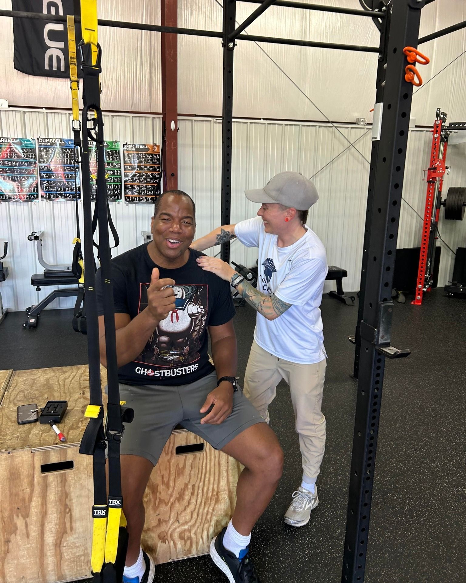 A man is giving a thumbs up to another man in a gym