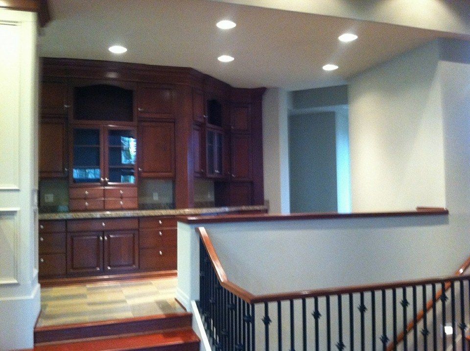 A kitchen with wooden cabinets and a black railing