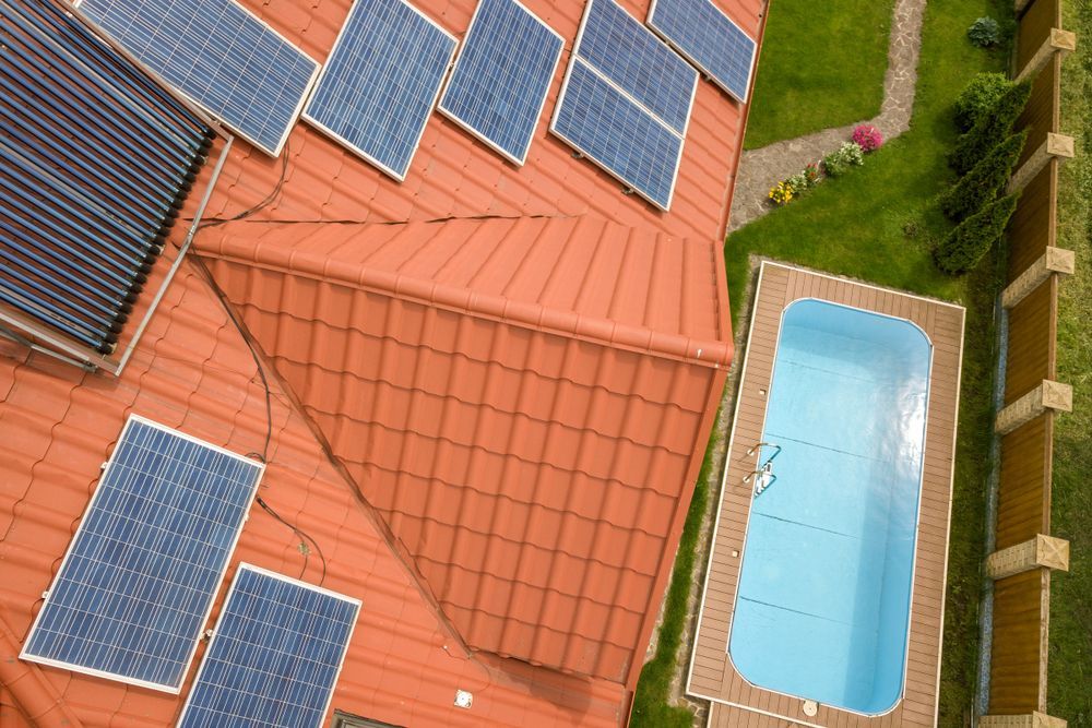 An Aerial View of a House With Solar Panels on the Roof and a Swimming Pool — Lismore Poolscene in Lismore, NSW