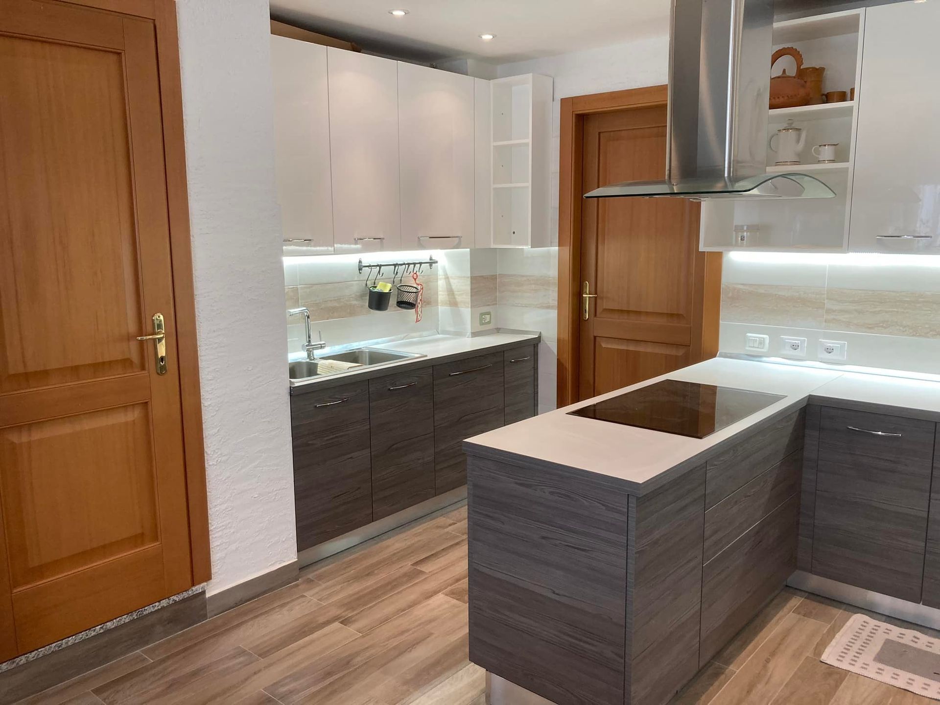 Una cucina con elettrodomestici in acciaio inossidabile e mobili in legno