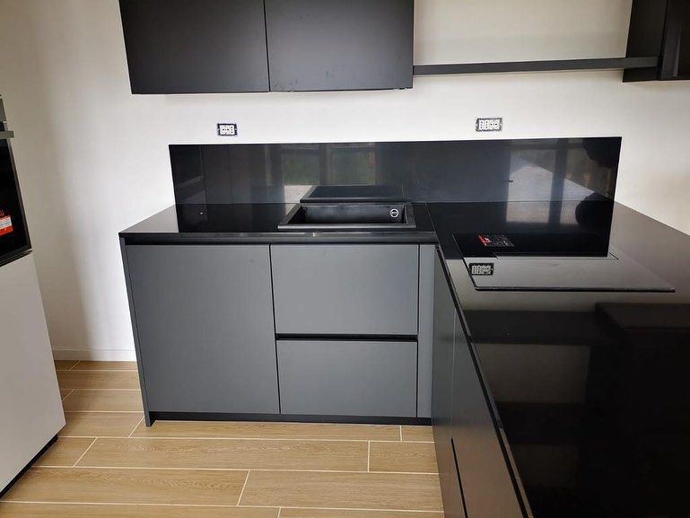 Una cucina con mobili neri e un piano di lavoro nero