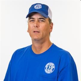 Man wearing blue cap and shirt with logo, looking forward against a white background.
