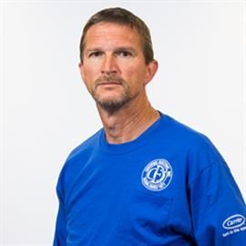 Man in blue shirt, serious expression. White backdrop.