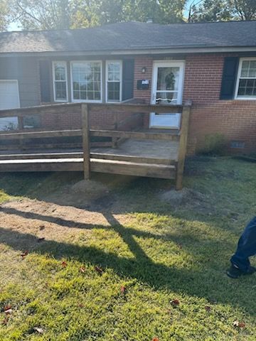 A brick house with a wooden deck in front of it.
