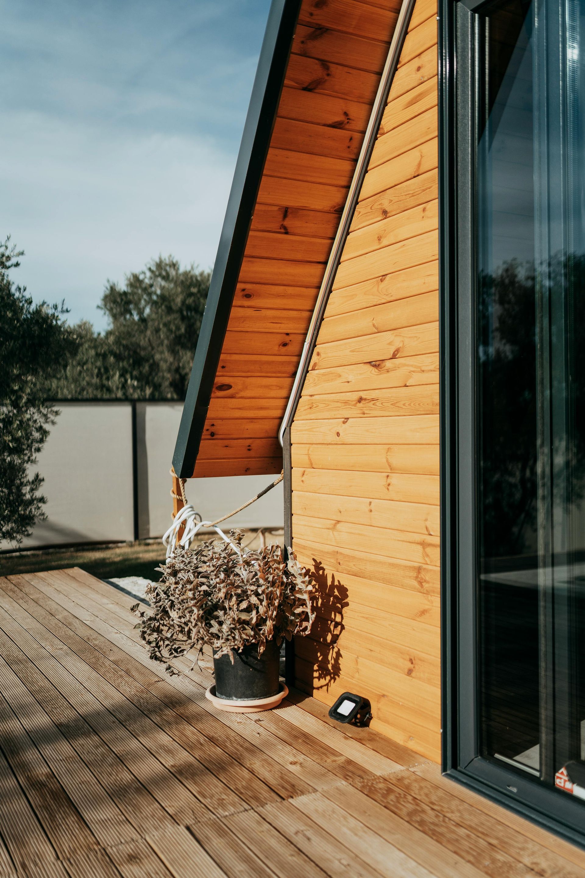 A wooden house with a sliding glass door and a wooden deck.