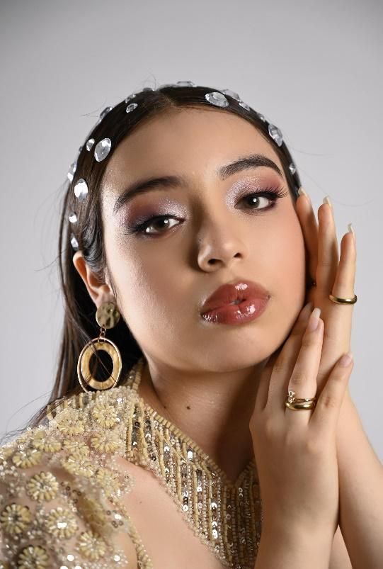 Un primer plano de una mujer que lleva una diadema y pendientes.