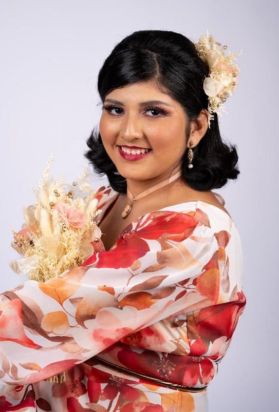 Una mujer con un vestido floral sostiene un ramo de flores.