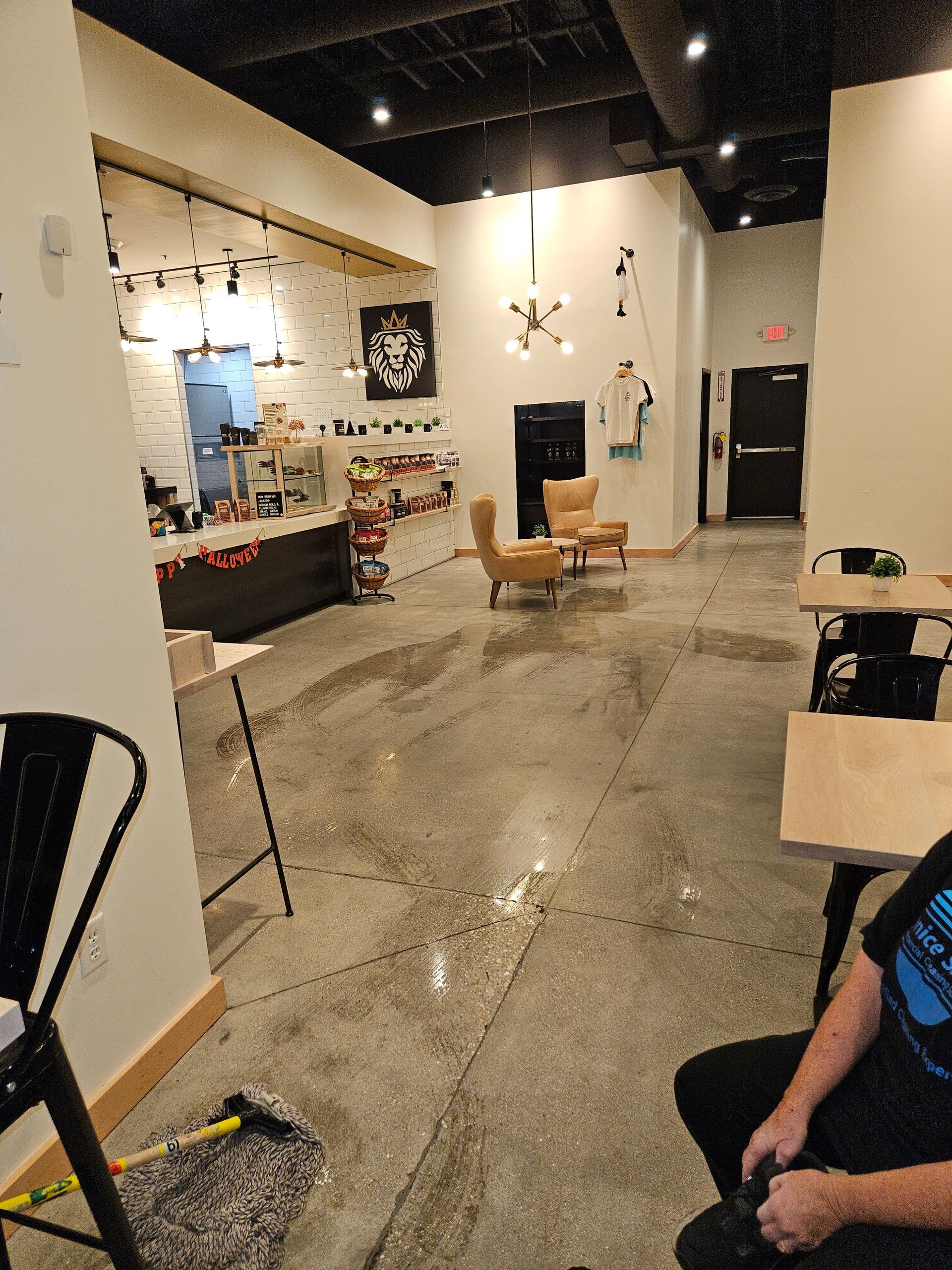 A man is sitting in a chair in a room with tables and chairs.