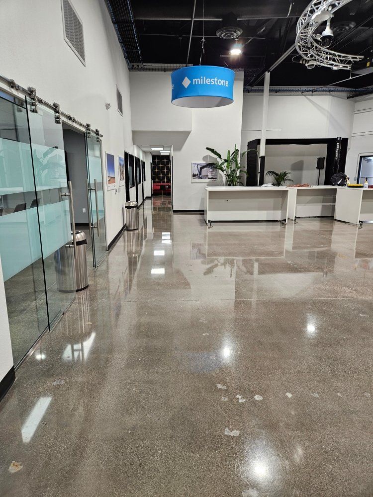 A large hallway with sliding glass doors and a blue sign hanging from the ceiling.