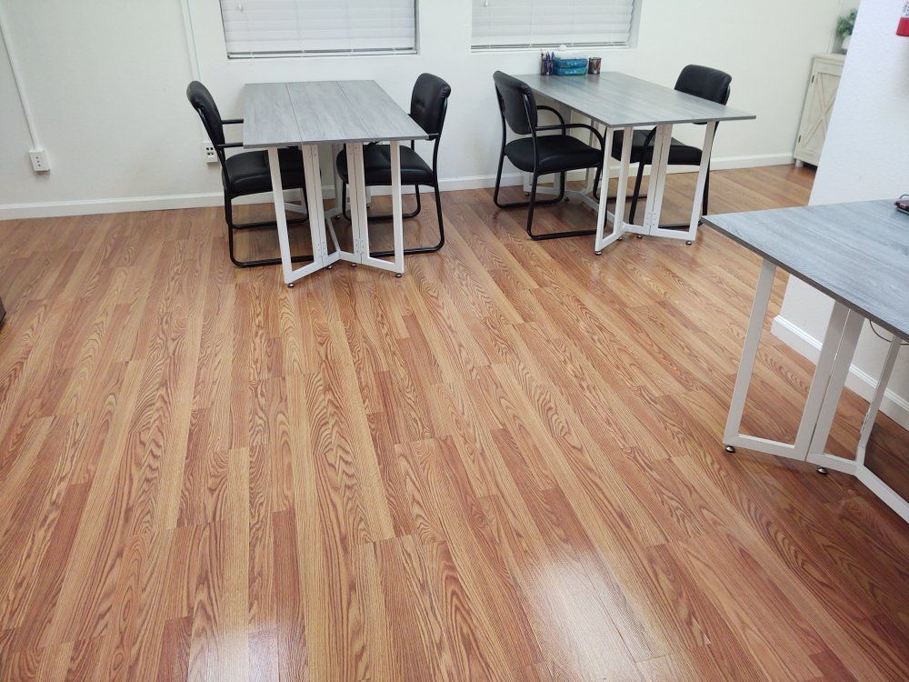 A room with wooden floors and tables and chairs.