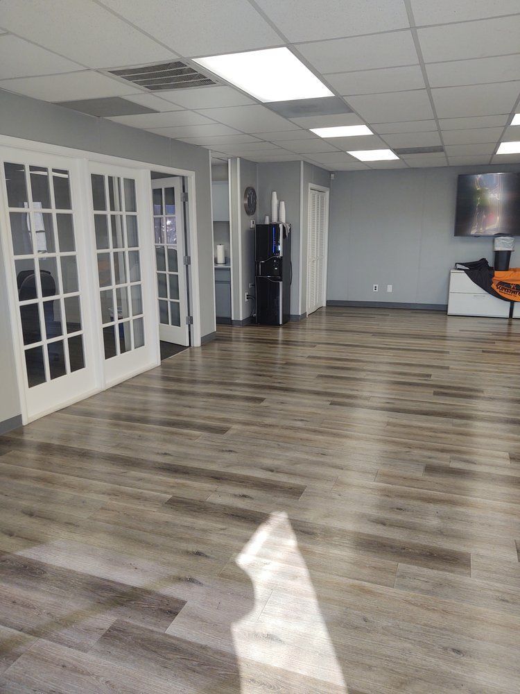 A large room with a wooden floor and french doors.