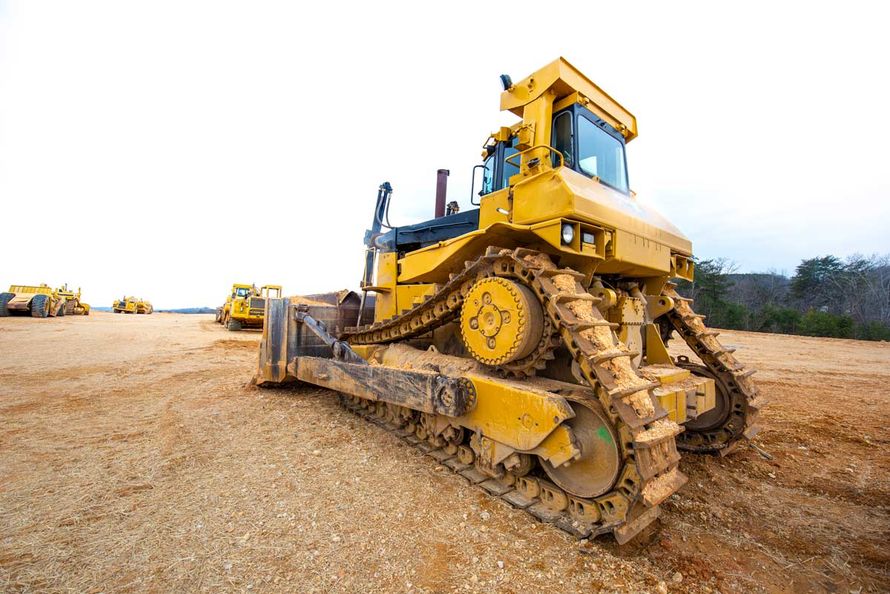 Construction bulldozer aginst white sky — Asheville, NC — Down To Earth Grading Inc.