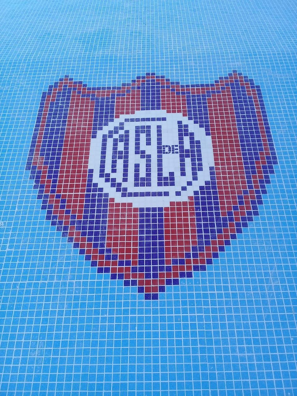 Mosaico del escudo del club San Lorenzo de Almagro; escudo azul, rojo y blanco.