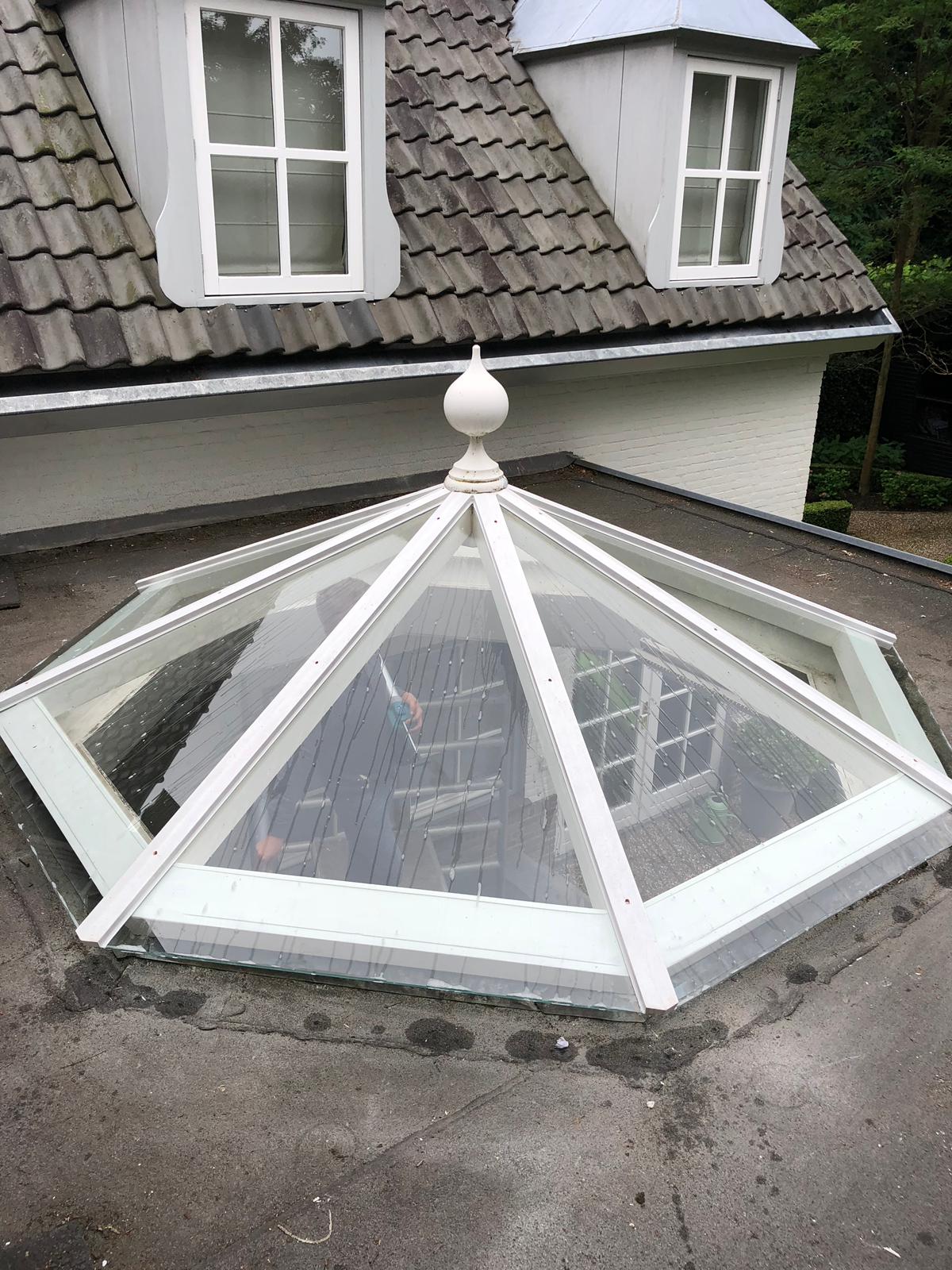 Een piramidevormig dakraam op het dak van een huis.