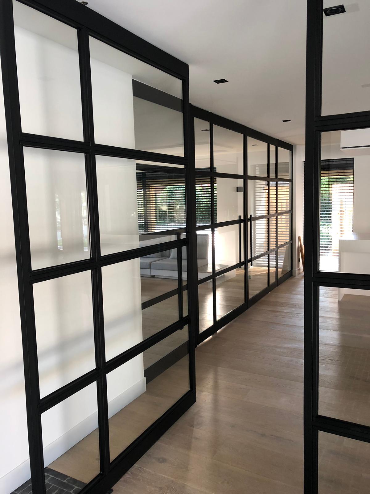 Een gang met veel glazen wanden en deuren