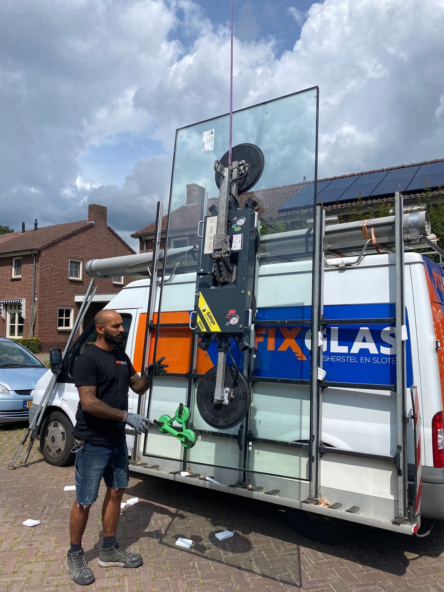 Een man staat voor een busje met een groot glas in zijn handen.