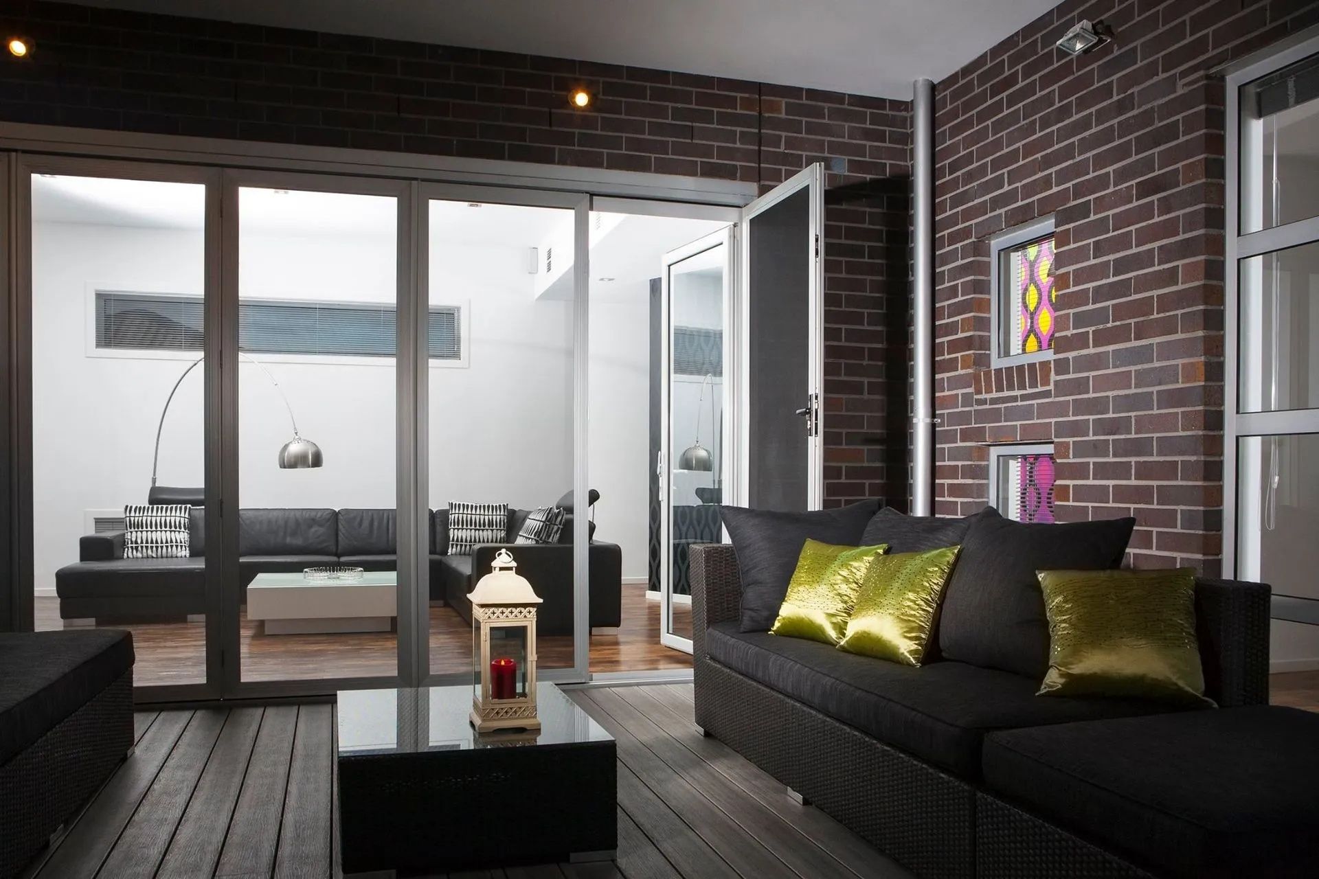 Living Room With Dark Brick Wall and Black Sofa — Keilbach Kitchens in Cairns, QLD