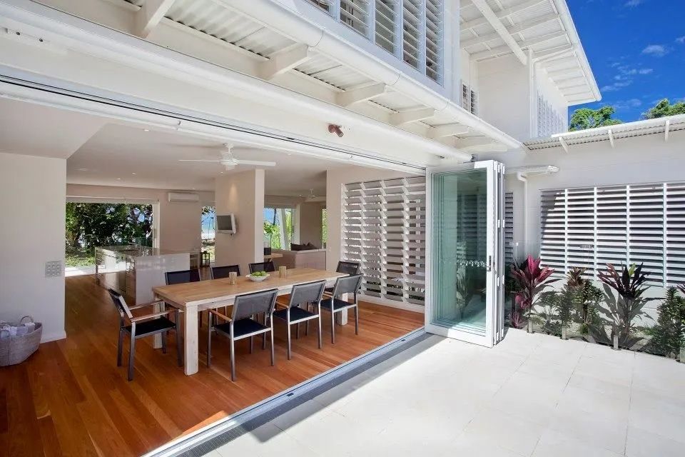 Open Dining Area With Folding Glass Doors — Keilbach Kitchens in Cassowary Coast, QLD