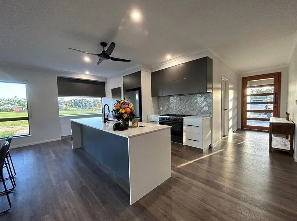 Modern Kitchen With Island, Range, and Dark Gray Range Hood — Keilbach Kitchens in Mission Beach, QLD