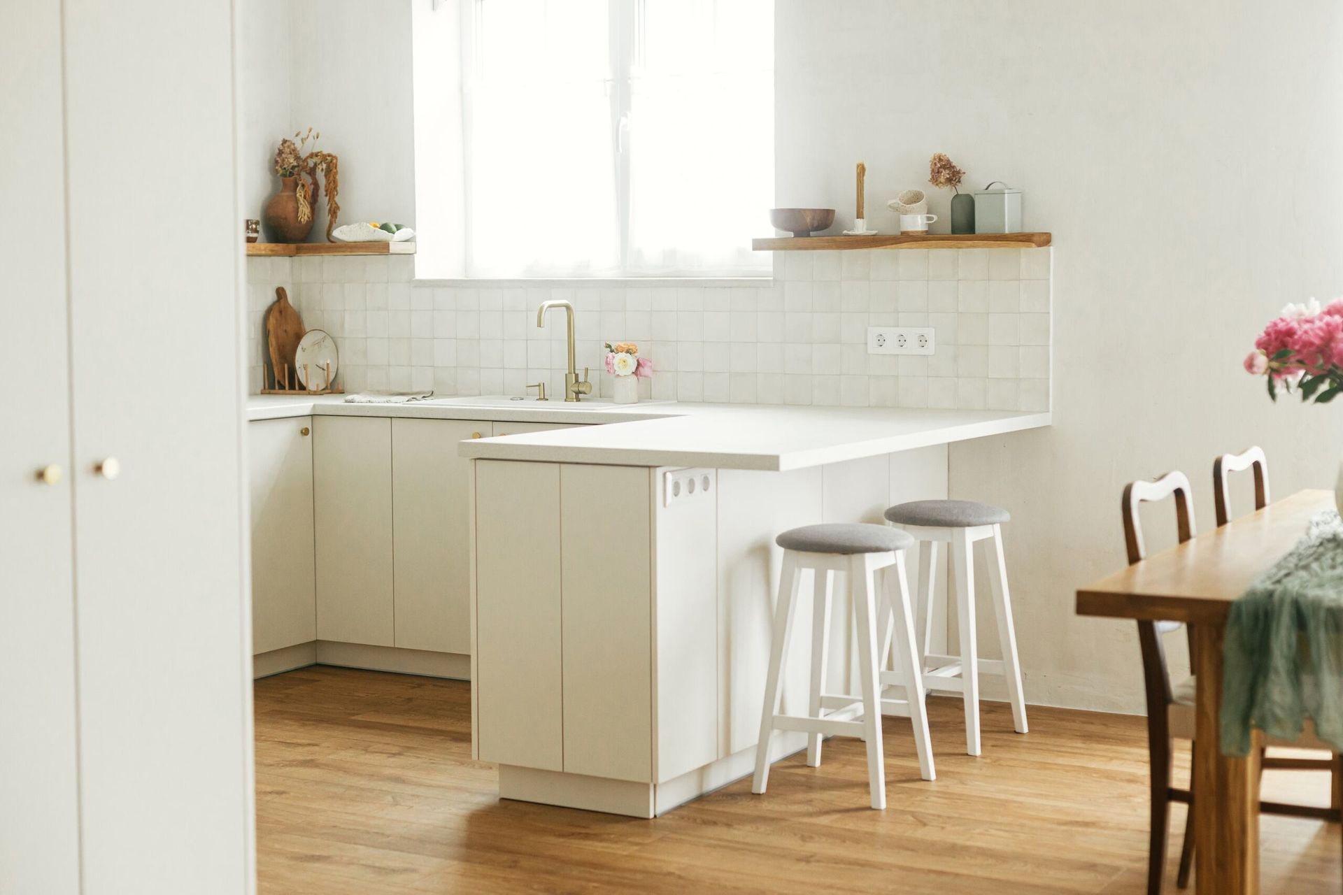 White Kitchen With Island, Stools, Dining Table, and Window — Keilbach Kitchens in Mission Beach, QLD