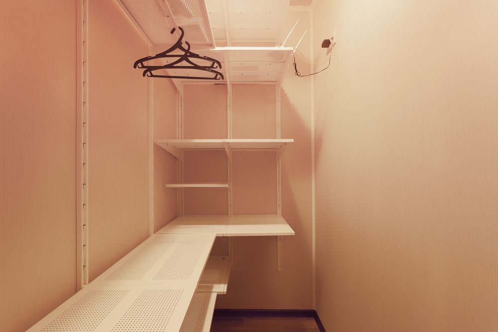 Empty Walk-in Closet With White Shelving and a Hanging Rod — Keilbach Kitchens in Tully, QLD