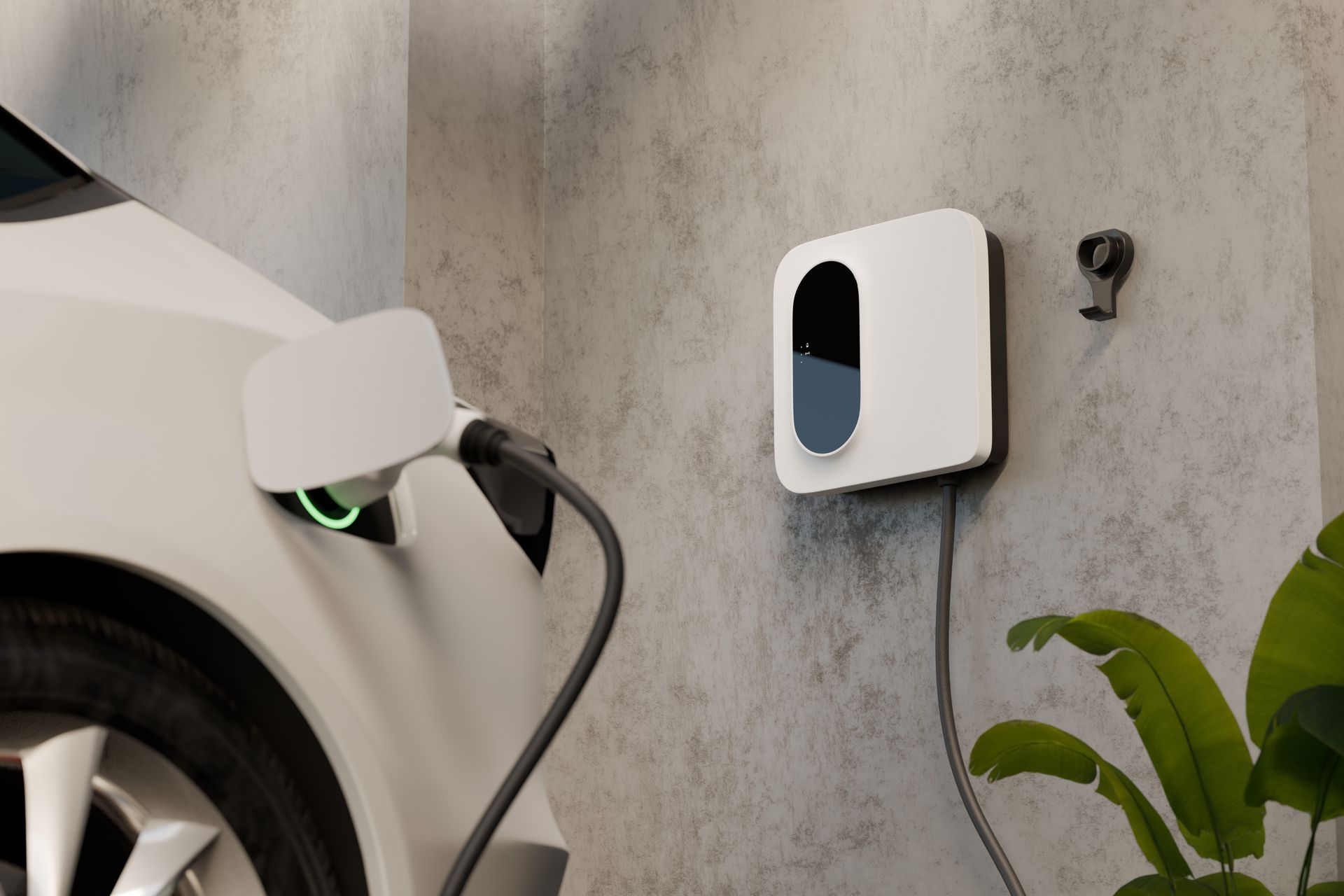 White electric car charging from a wall-mounted charging station in a garage.