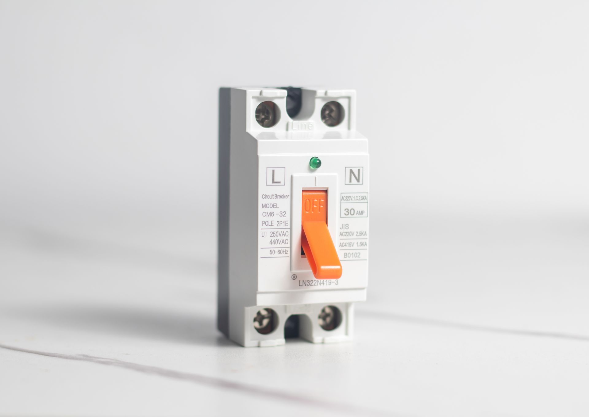 White circuit breaker with an orange switch in the on position against a white background.
