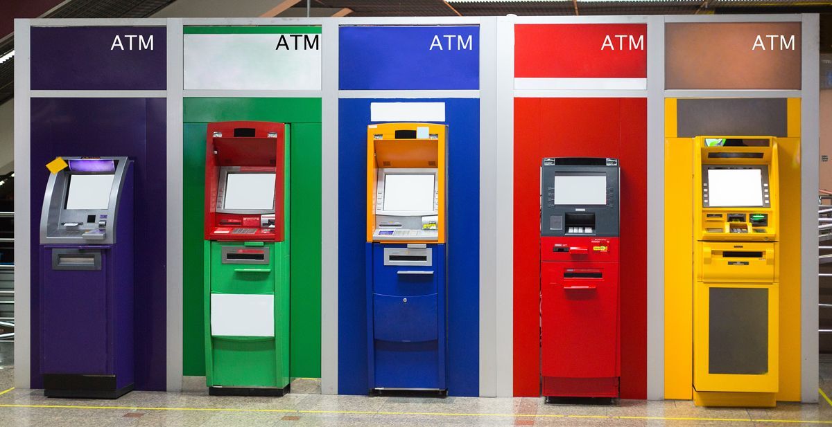 four different colored atm machines are lined up in a row
