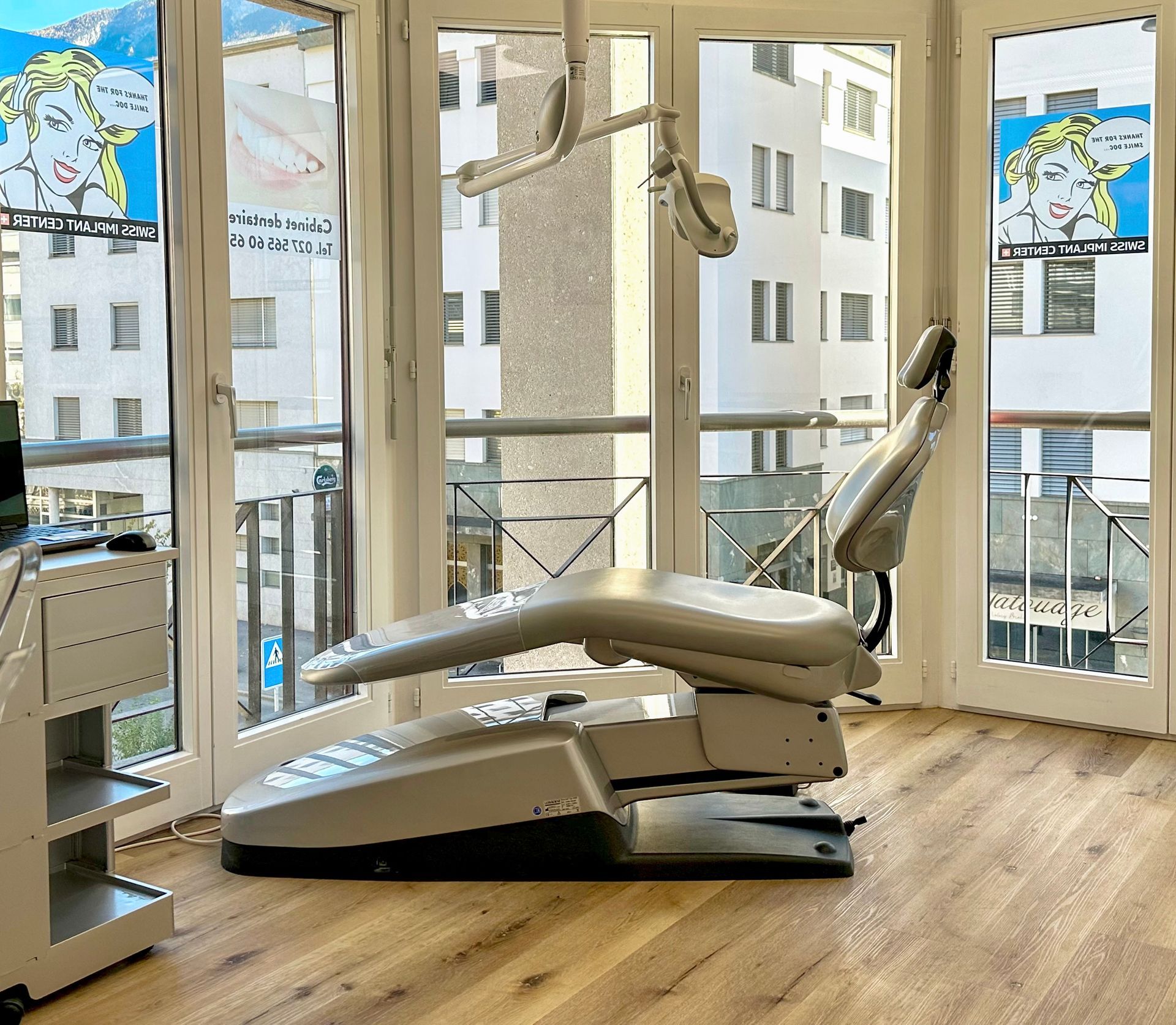 Une chaise dentaire dans une pièce avec beaucoup de fenêtres