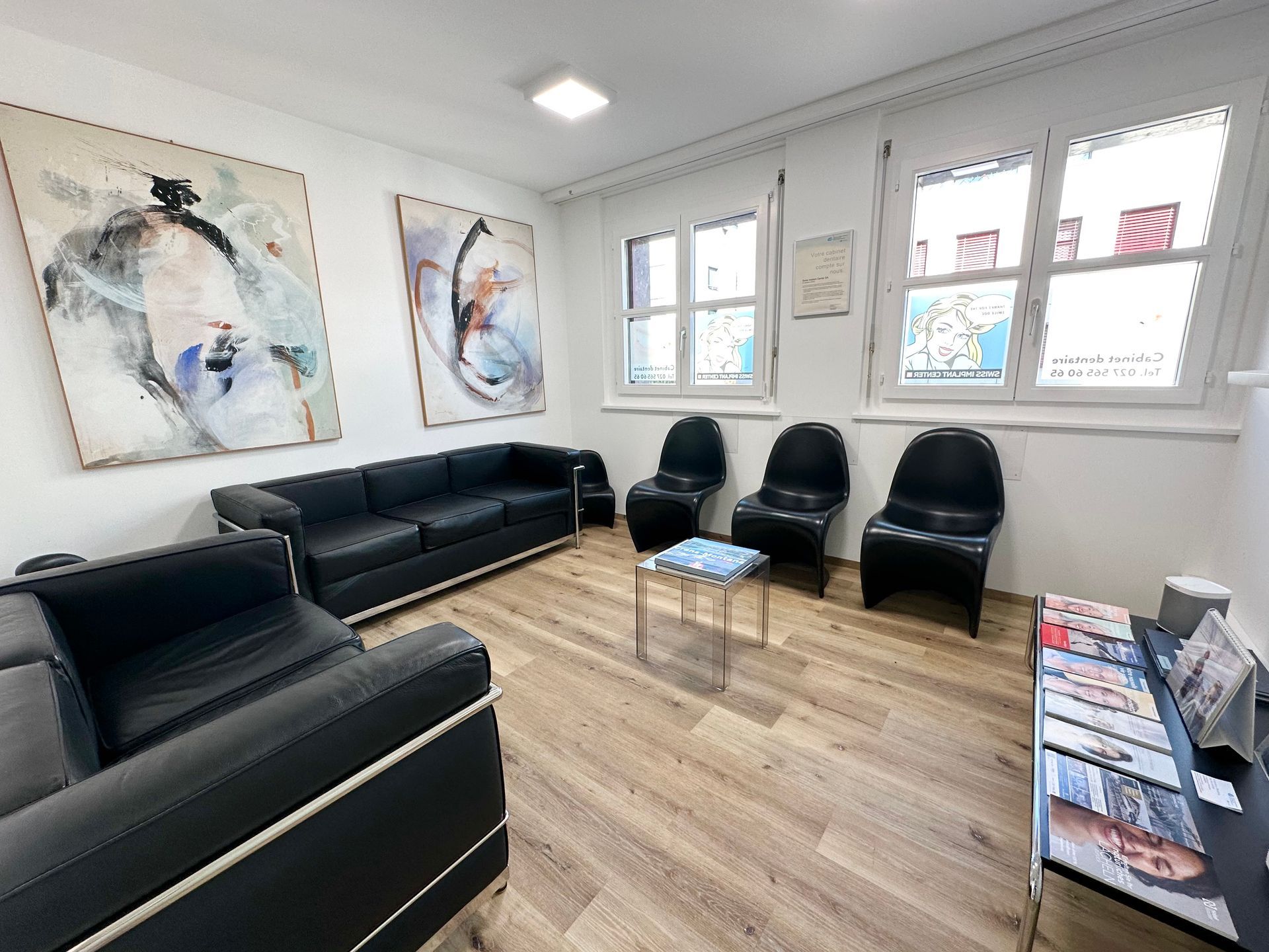Une salle d'attente avec un canapé, des chaises et une table.