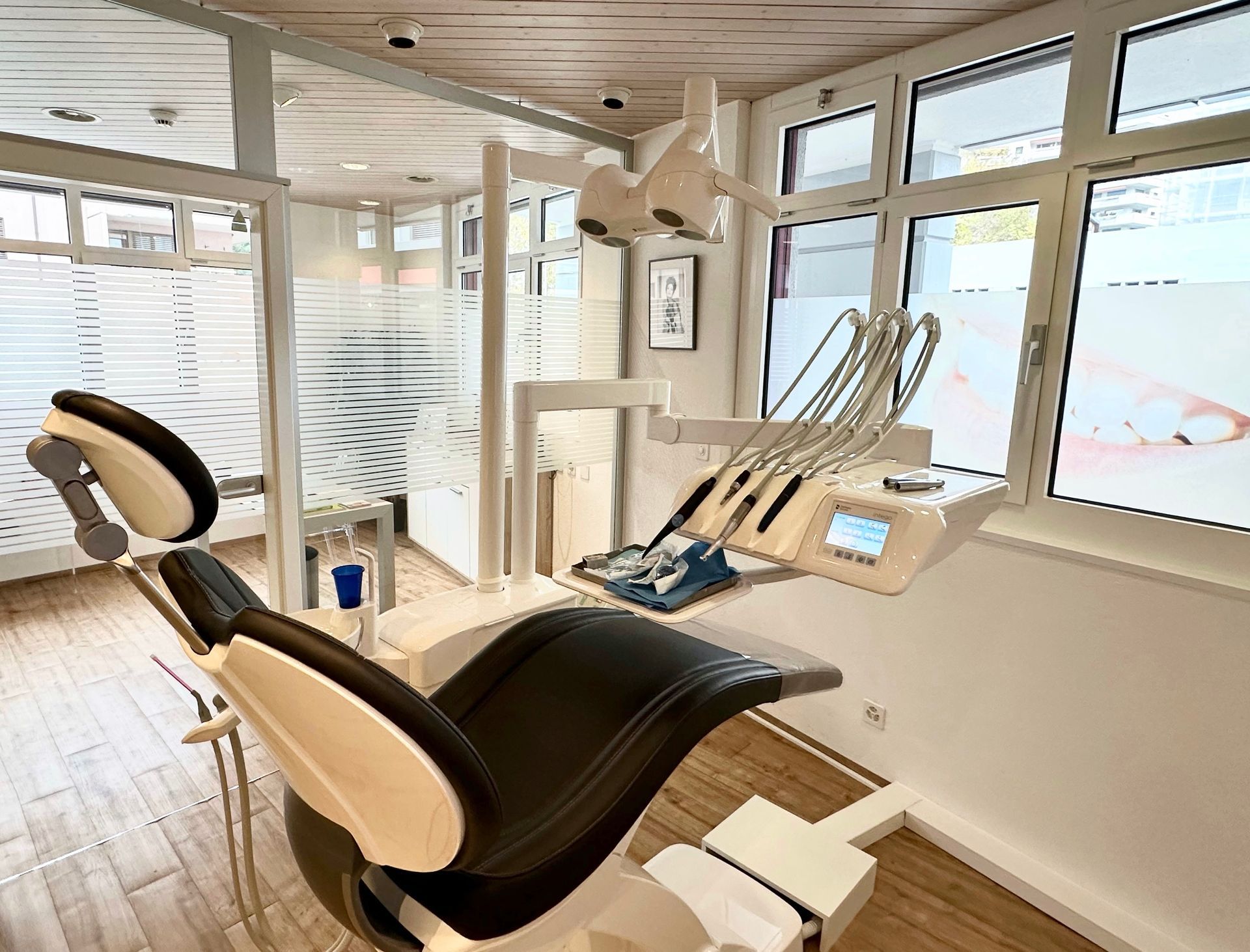 Une chaise dentaire dans un cabinet dentaire avec beaucoup de fenêtres