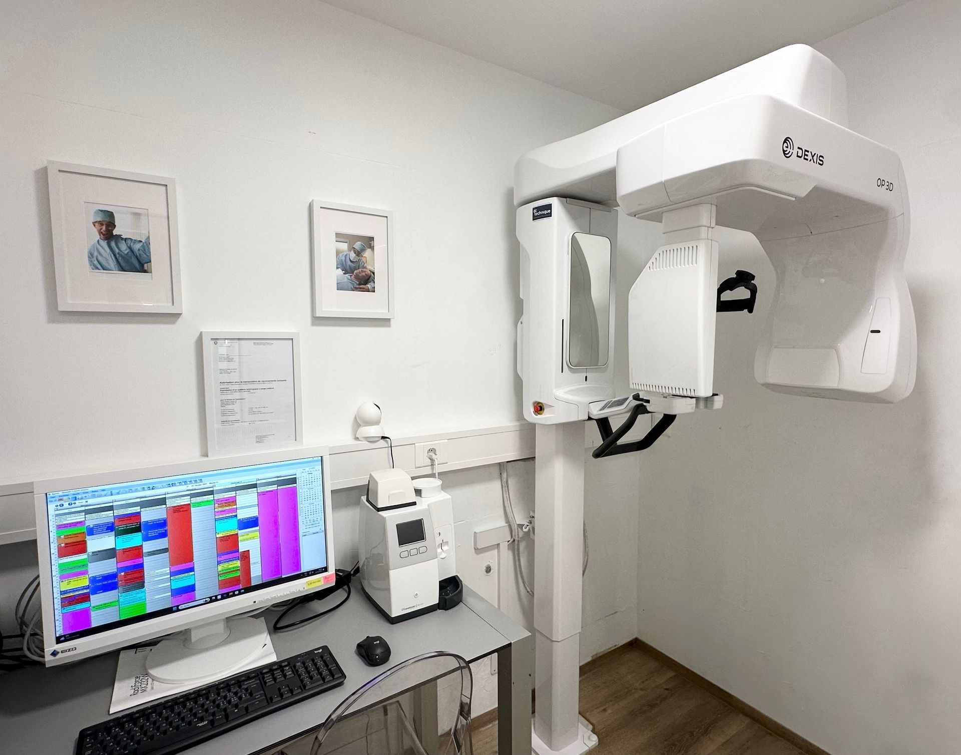 Un ordinateur est posé sur un bureau à côté d'une machine dans une pièce.