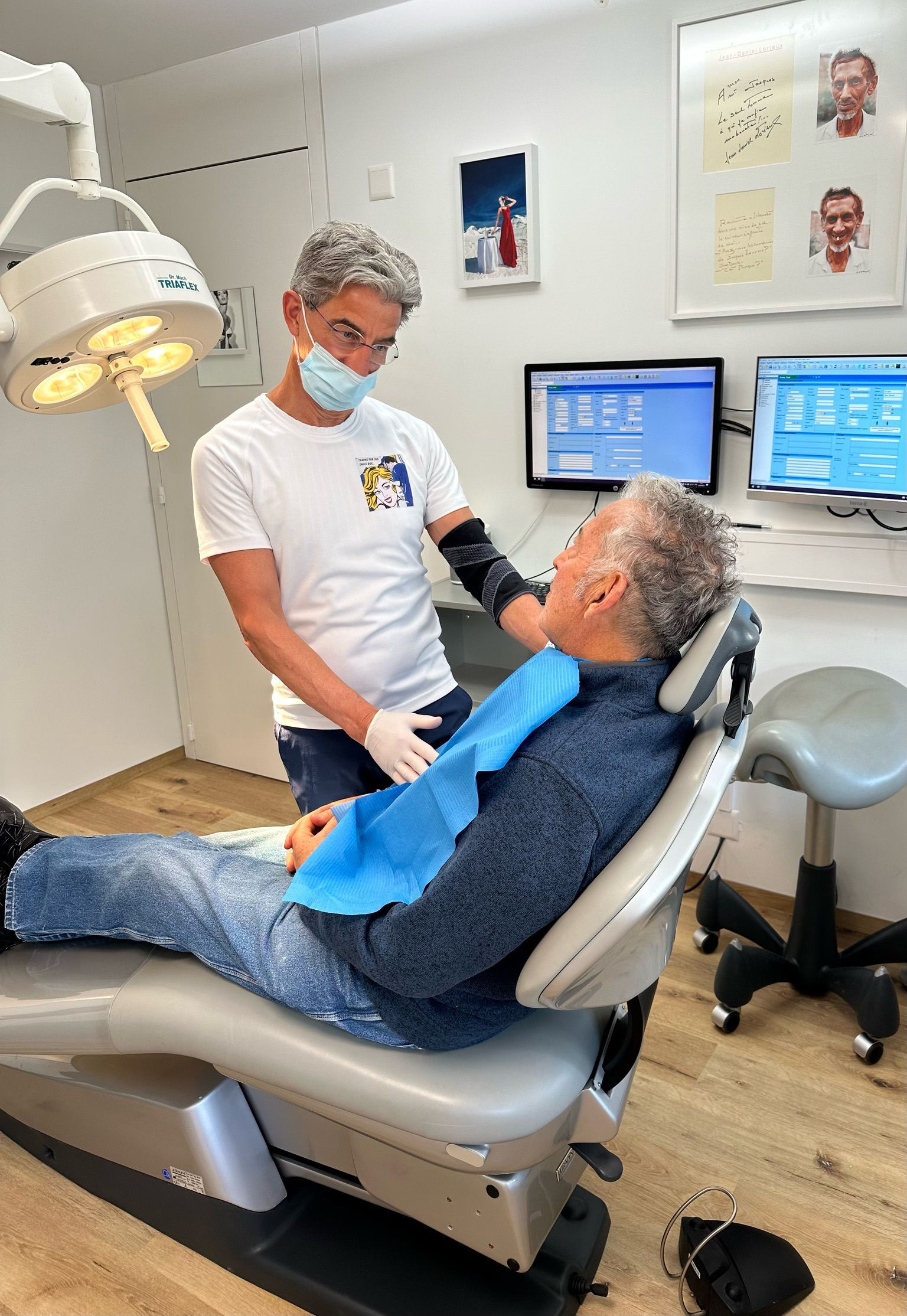Un homme est assis sur une chaise dentaire et parle à un dentiste.