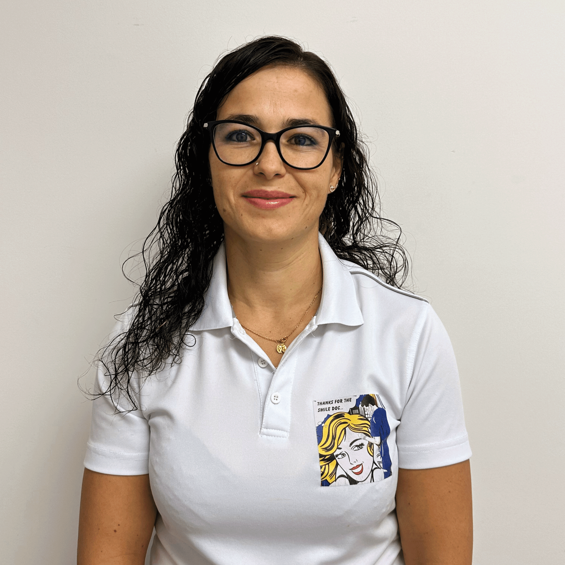 Une femme portant des lunettes et un polo blanc avec la photo d'une femme dessus.
