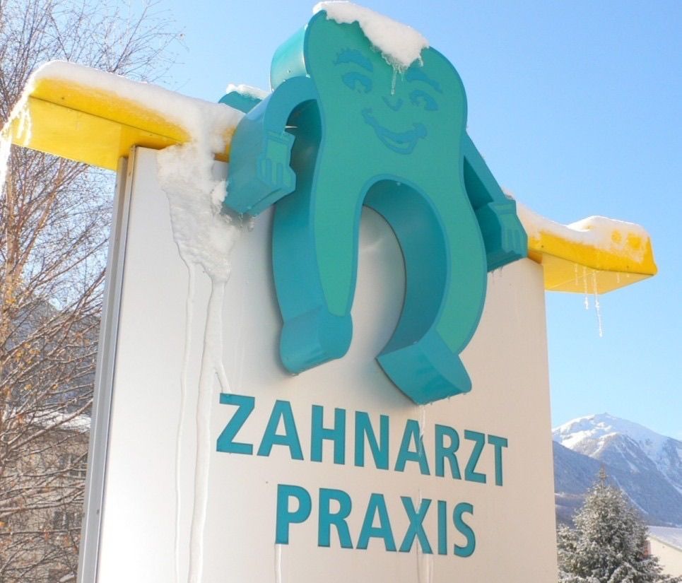 Un panneau indiquant le cabinet dentaire est recouvert de neige