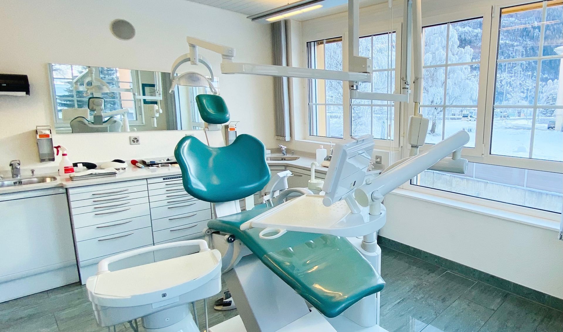 Un cabinet dentaire avec une chaise dentaire et un miroir