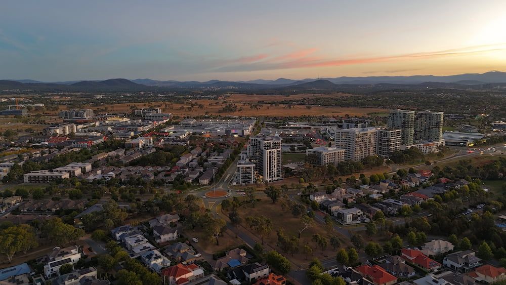 An Aerial View Of A City At Sunset With Mountains In The Background — Proud Cleaning Canberra in Gungahlin, ACT