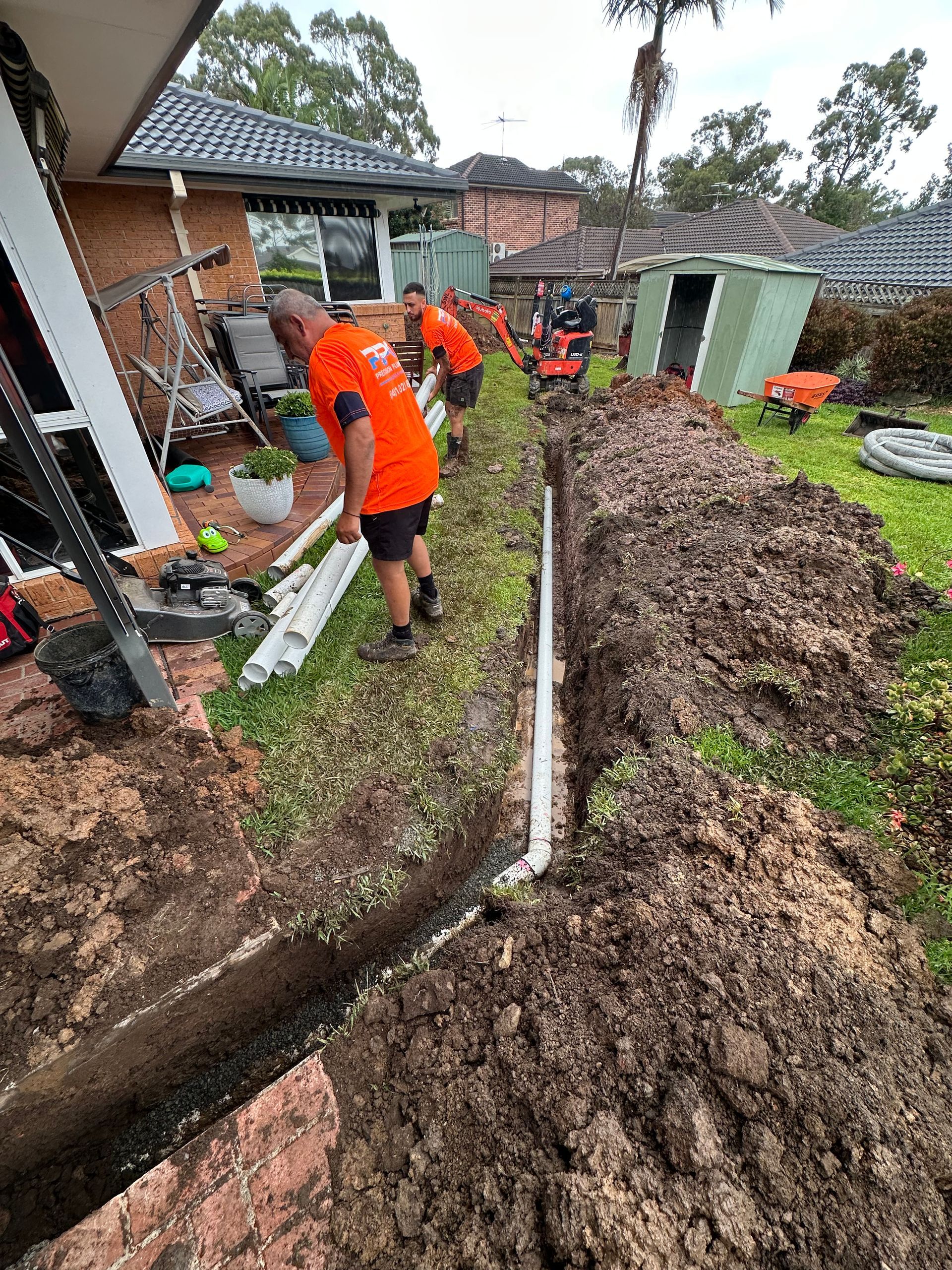A man is kneeling on the floor with a toolbox full of tools.