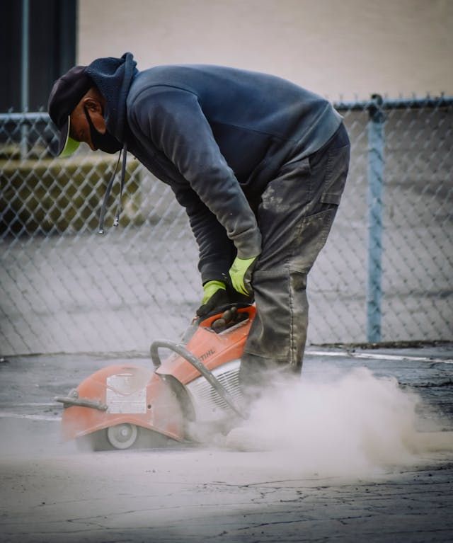 Worker applying concrete patching material to restore a damaged patio.