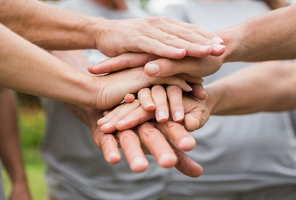Volunteers layering hands
