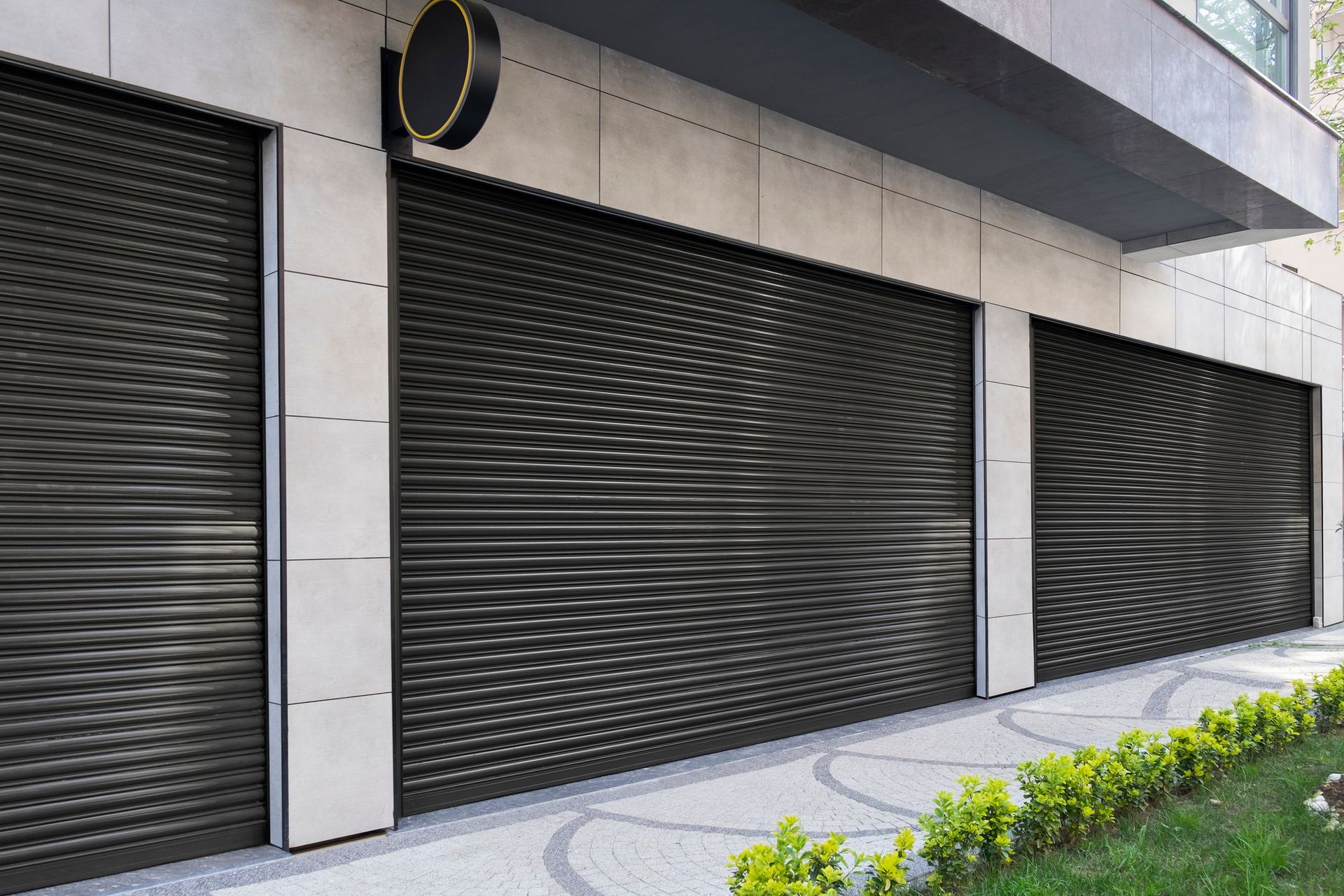 A building with a row of black roller shutters on the side of it.
