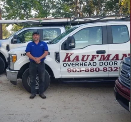 Two kaufman overhead door trucks are parked next to each other