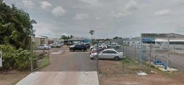 Cars parked in a car wash, fence in foreground, cloudy sky. — KND Autos in Berrimah, NT