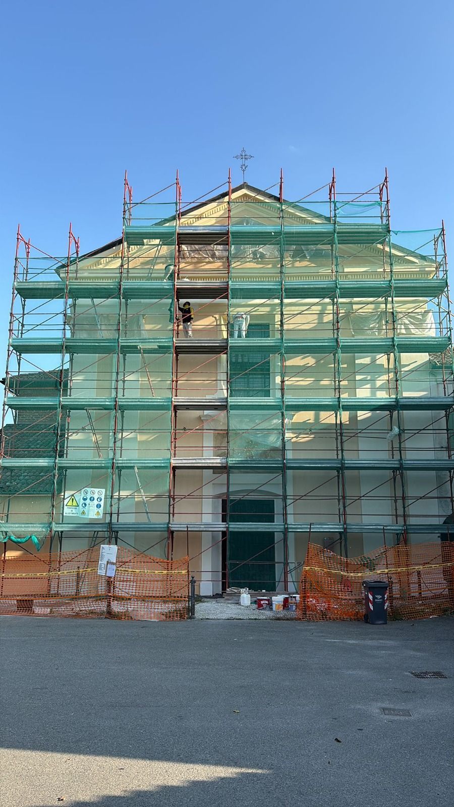 Facciata della chiesa in costruzione; impalcature circondano l'edificio.