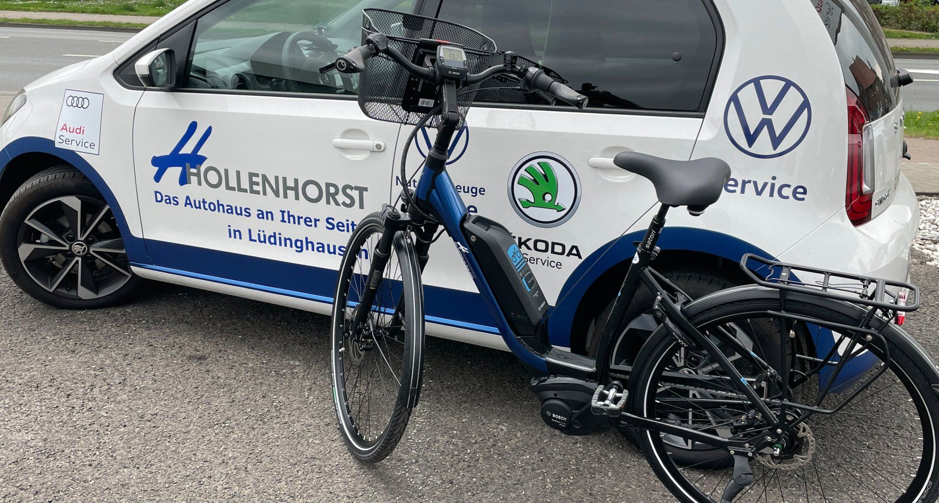 Ein Fahrrad steht neben einem weißen Auto.