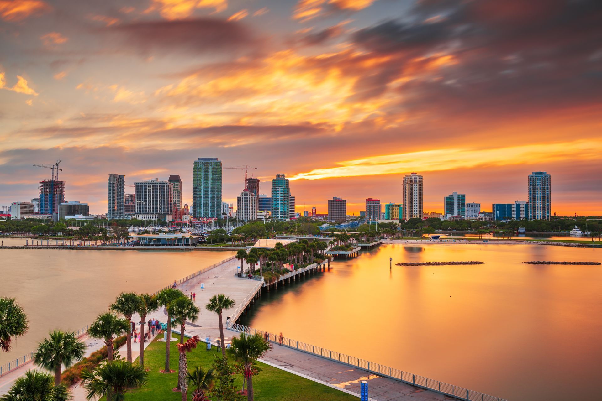 An aerial view of a city skyline over a body of water at sunset.