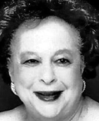 A black and white photo of an older woman smiling.