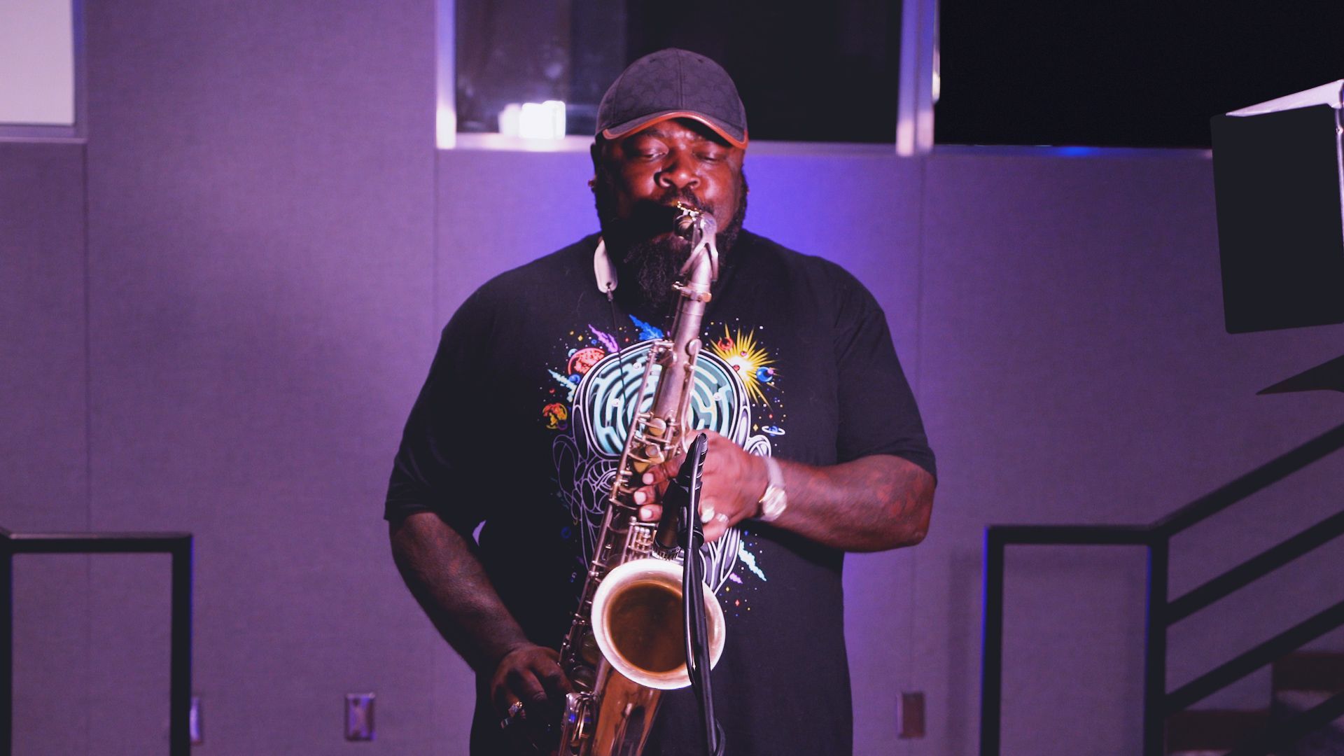 a man is playing a saxophone in a dark room .