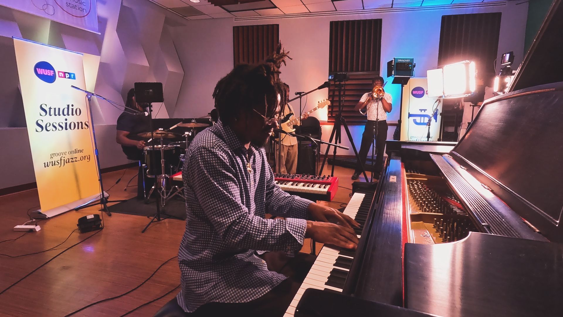 A man is playing a piano in a room with a sign that says studio session